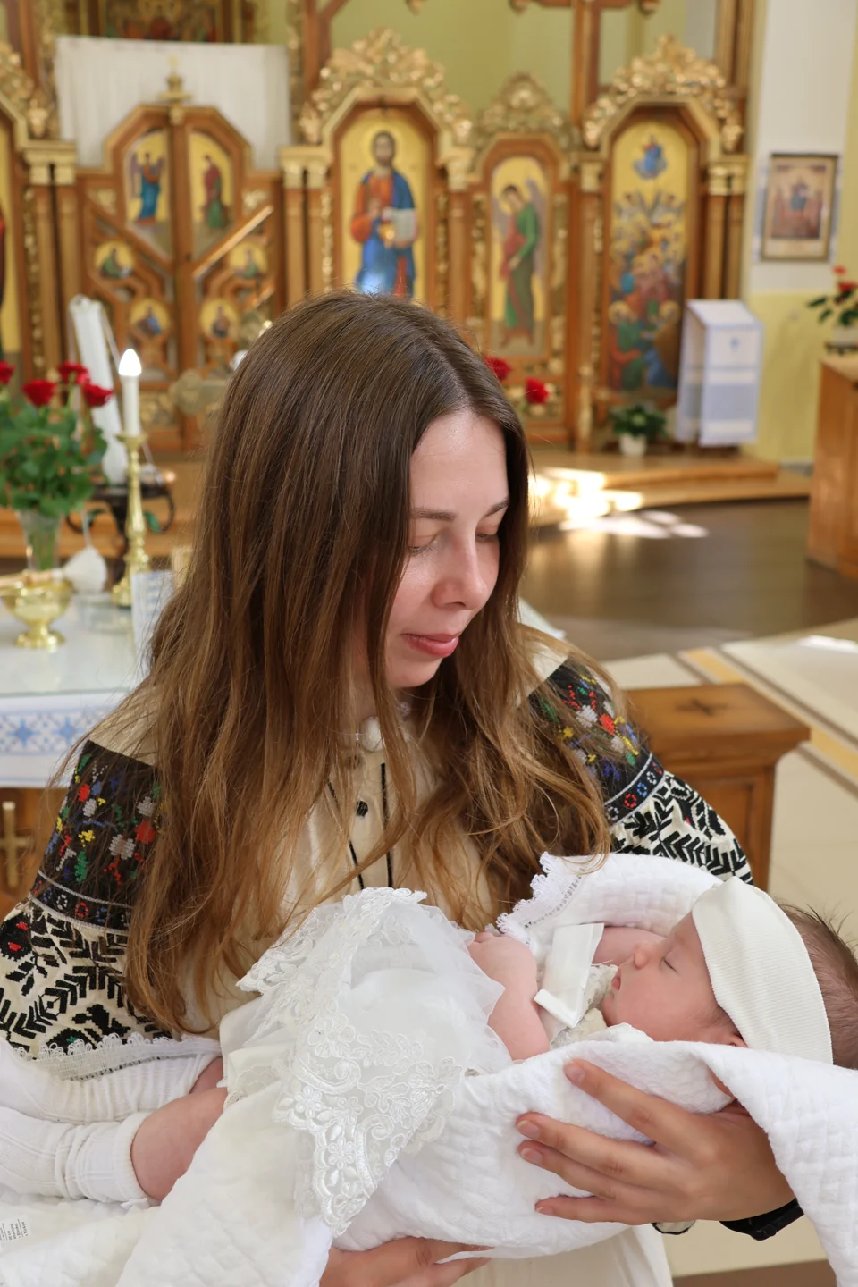 Софійка спить на руках під час світлого родинного моменту в церкві